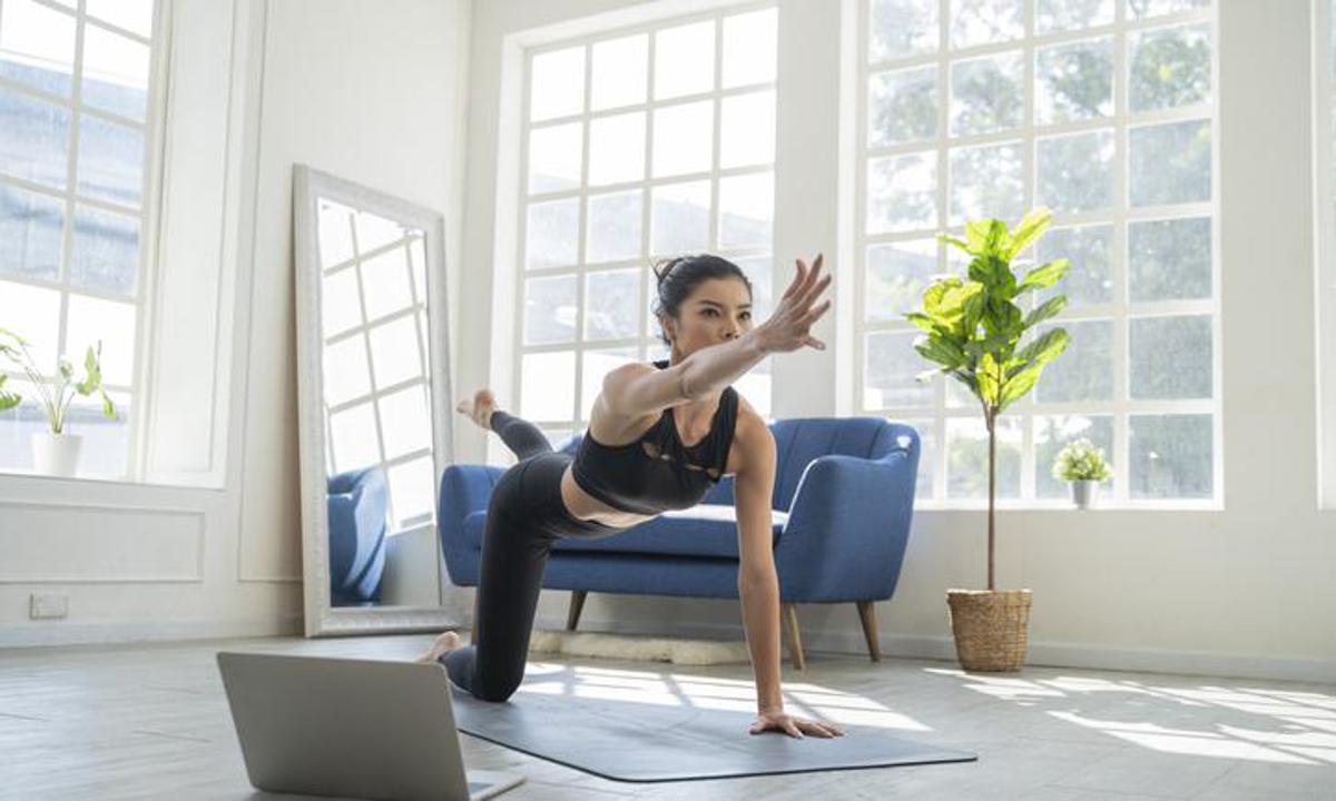Woman doing exercises through online videos at home
